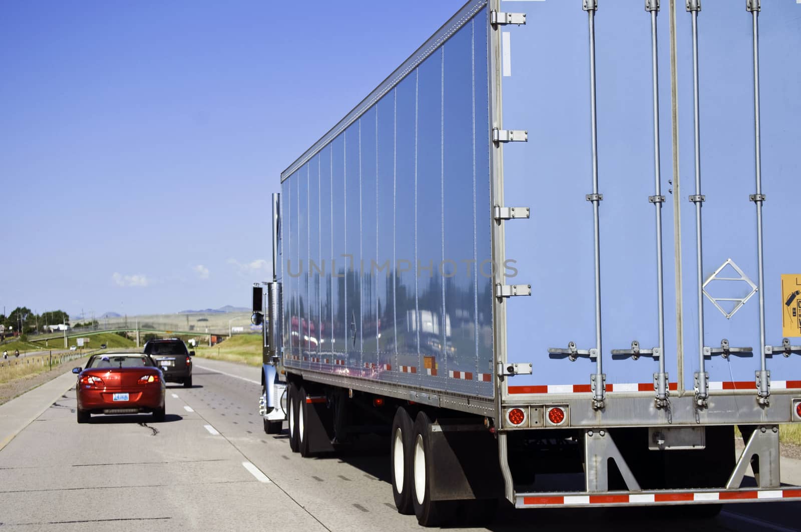 Two four-wheelers passing a big truck on the interstate highway