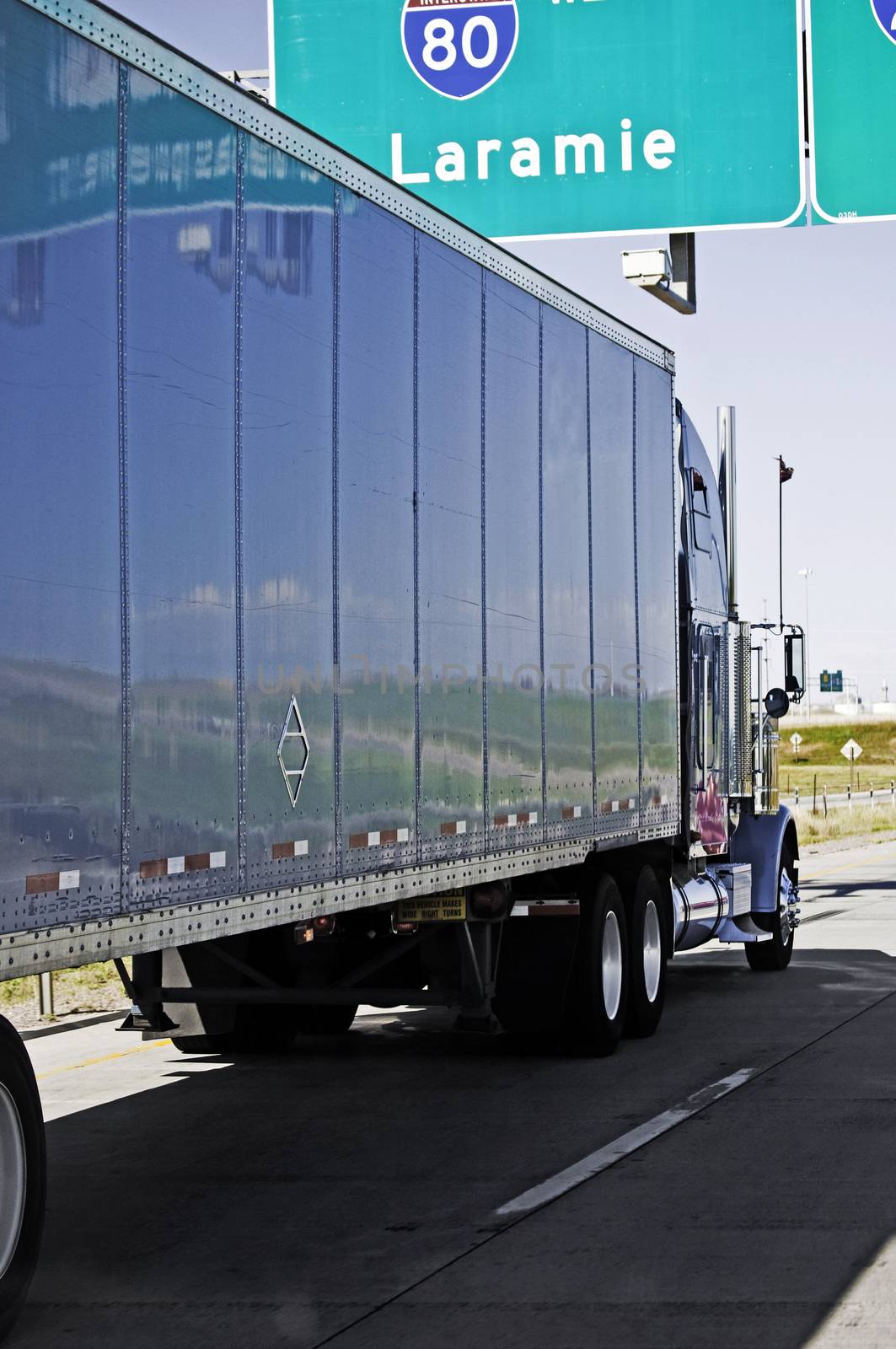 Shady side of a big truck showing reflective side of the trailer