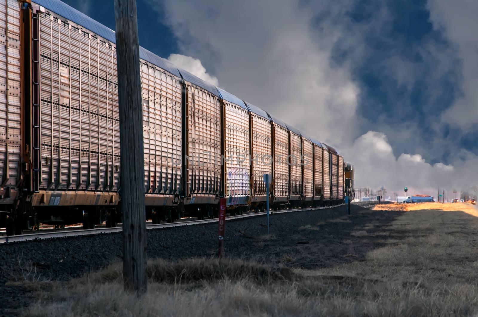 Freight train entering a small rural town in the foggy early morning.