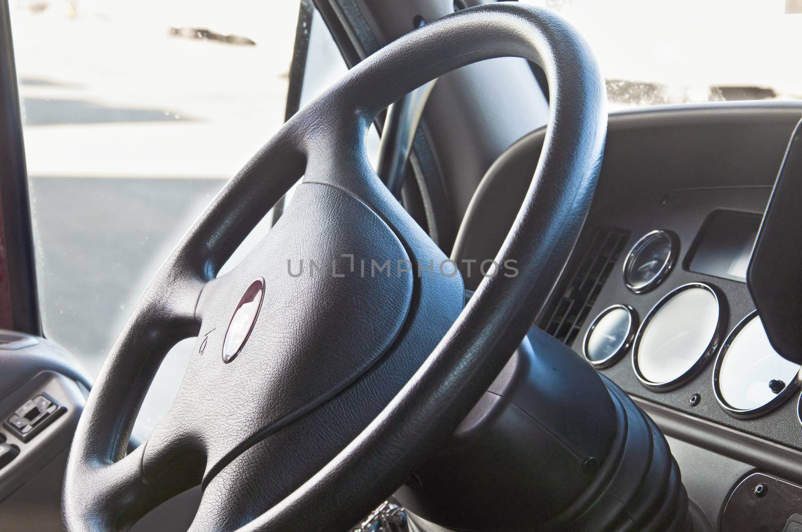 Steering wheel and dash of an eighteen wheeler semi-truck.