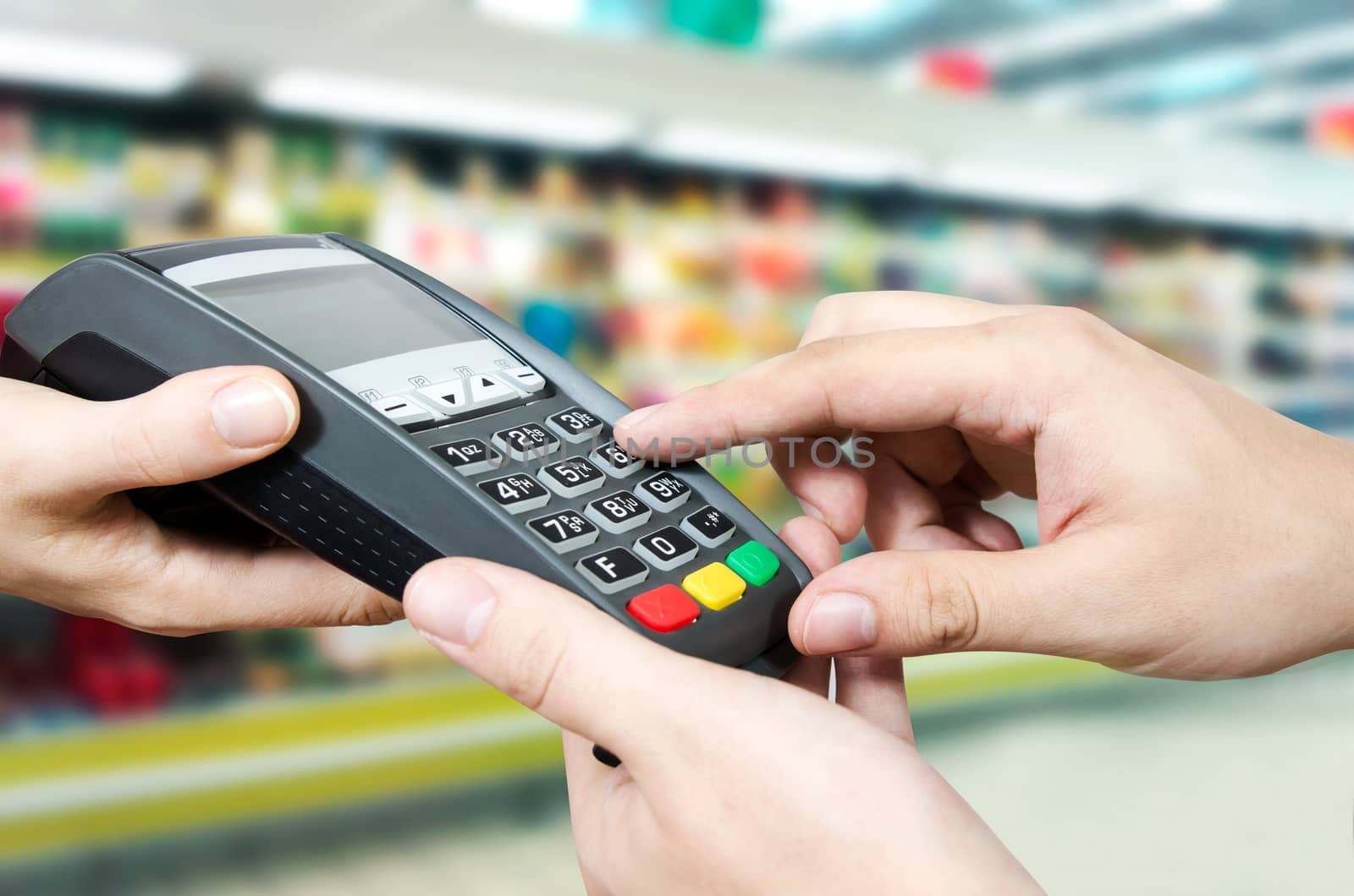 Hand with credit card swipe through terminal for sale in supermarket