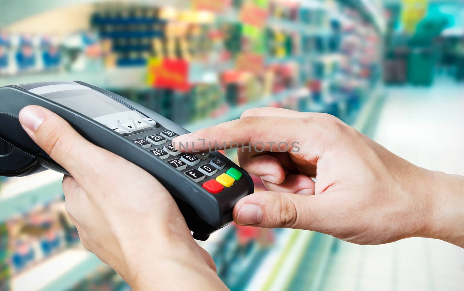 Hand with credit card swipe through terminal for sale in supermarket