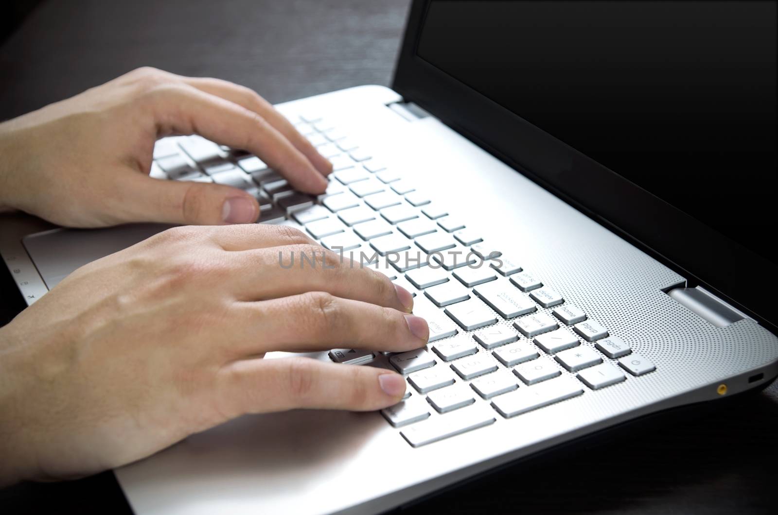 Man using laptop with white keyboard. Working in office