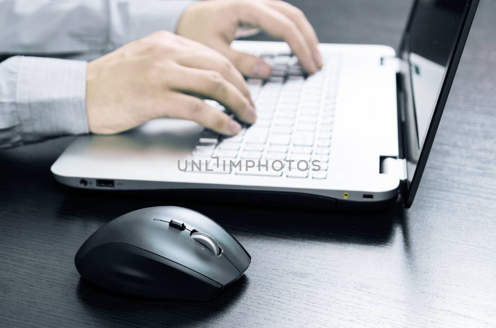 Man using laptop with white keyboard. Working in office