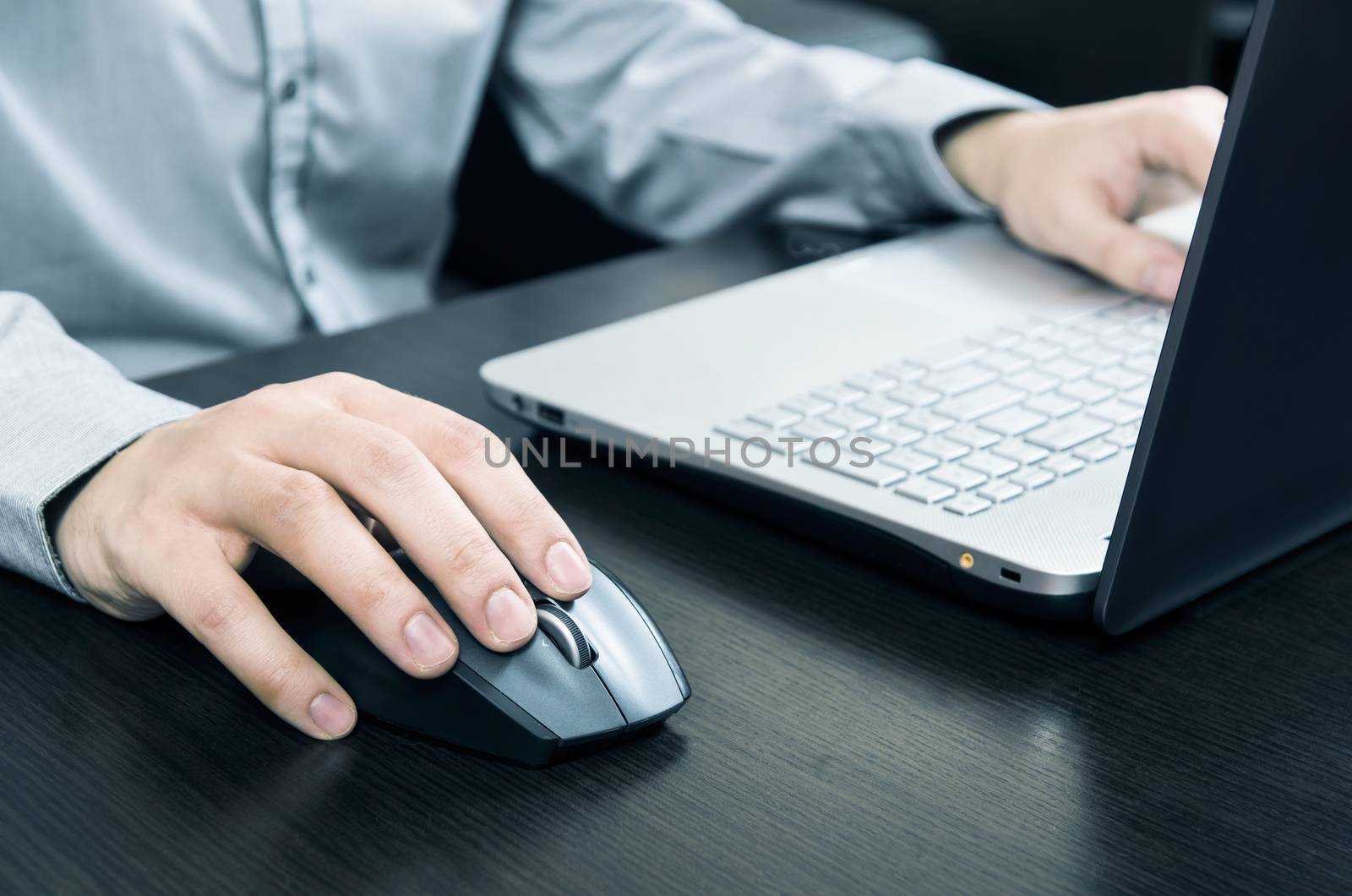 Man using laptop with white keyboard. Working in office