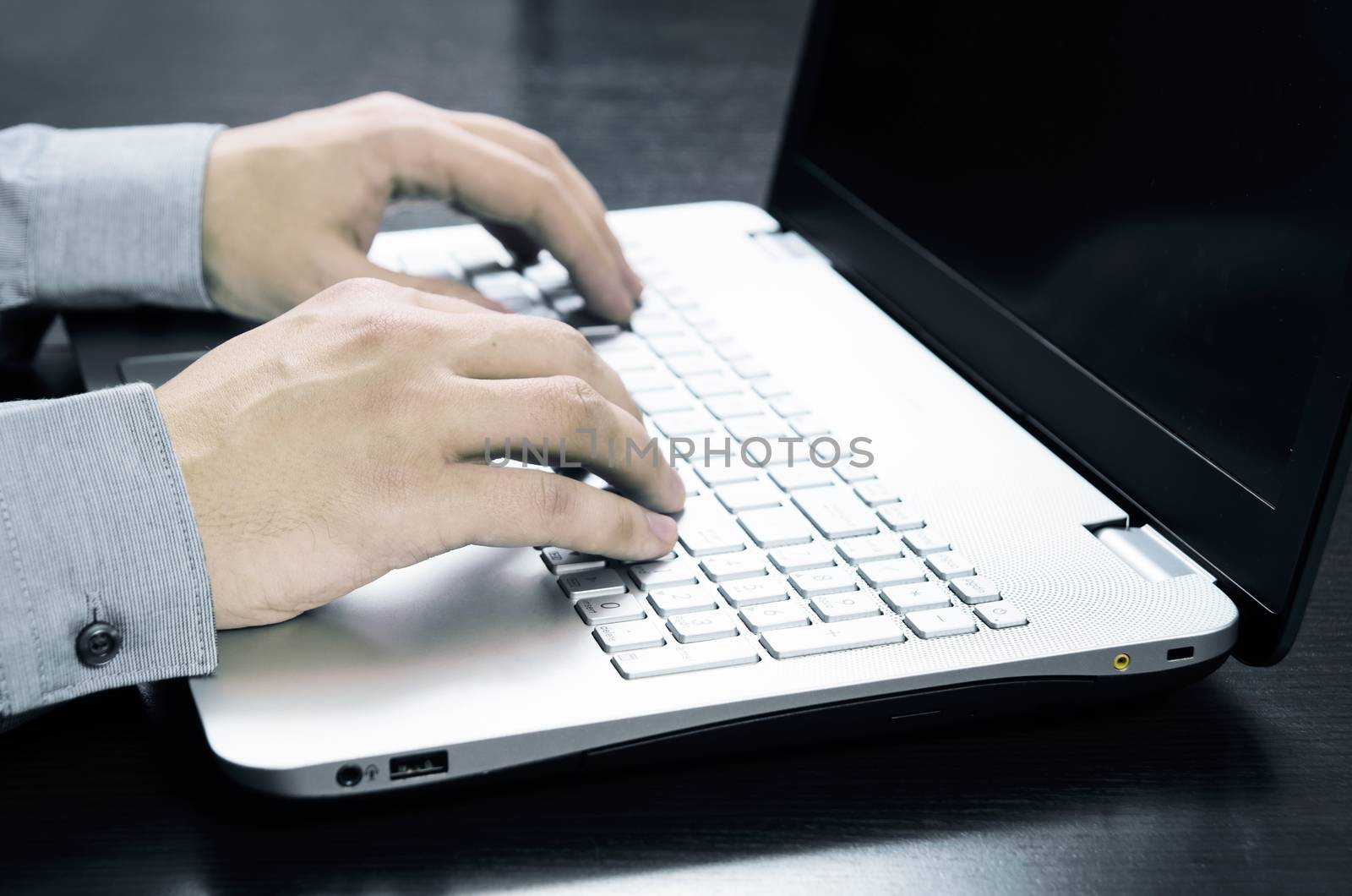 Man using laptop with white keyboard. Working in office