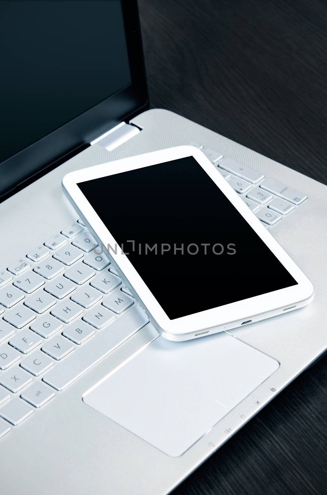 Laptop with white digital tablet on desk  by simpson33