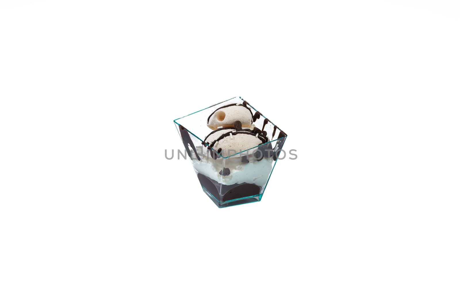 In the picture a cupcake with choccolate and cream in a plastic cup,isolated on white background.