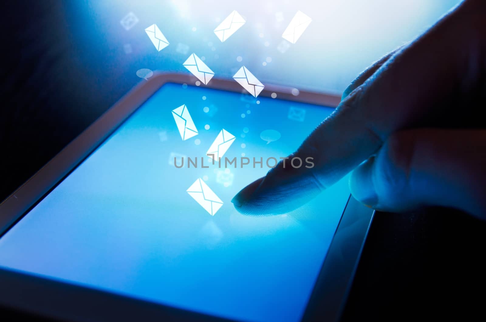 Finger touching on tablet. Messages fly from the screen