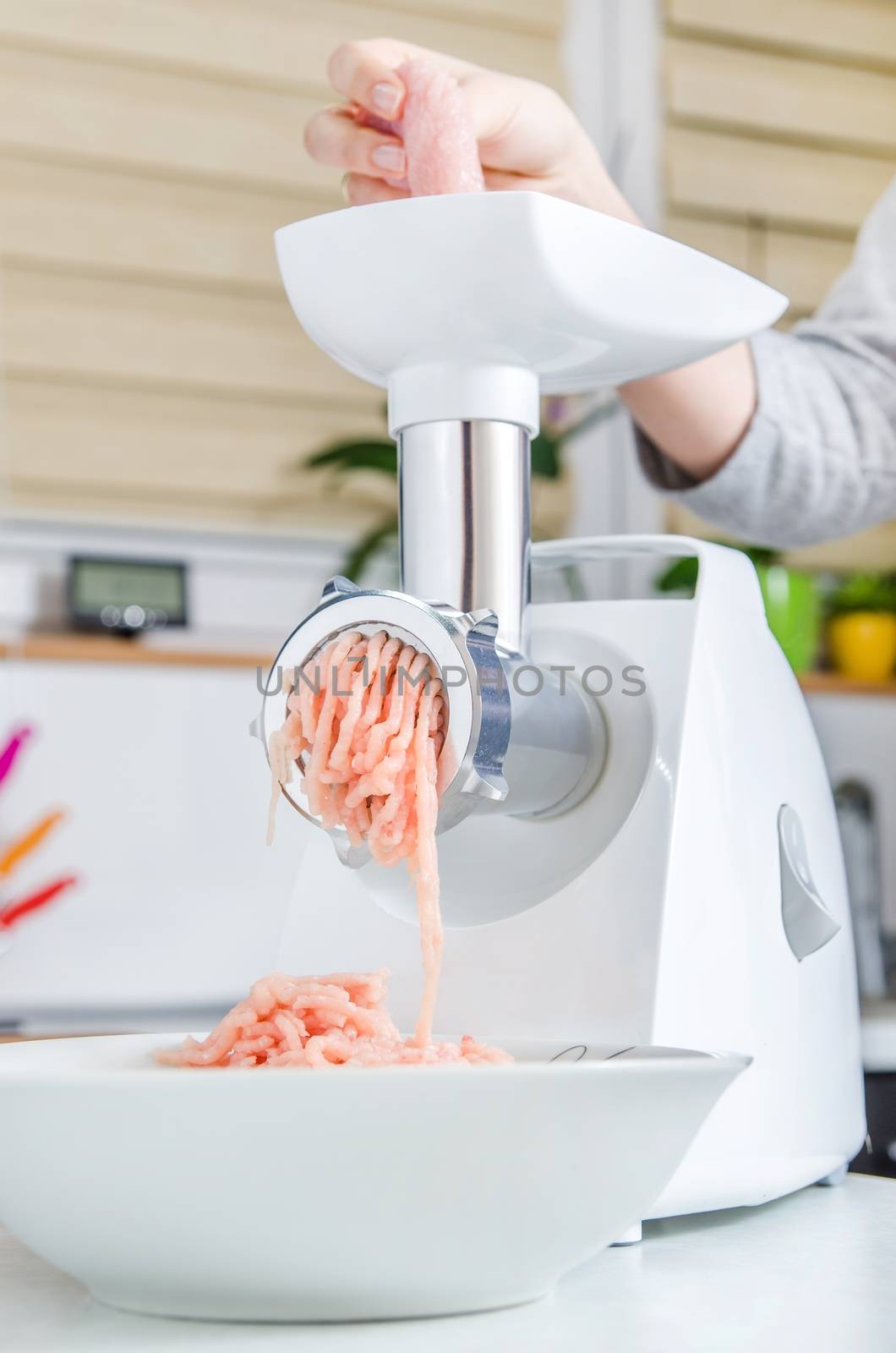 Grinder with minced meat in modern kitchen