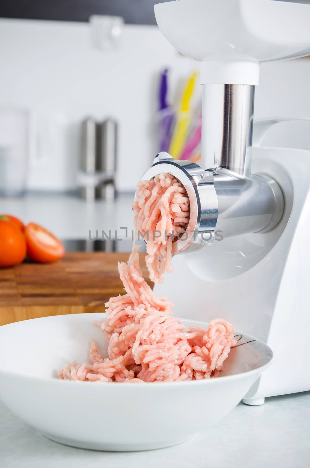 Grinder with minced meat in modern kitchen