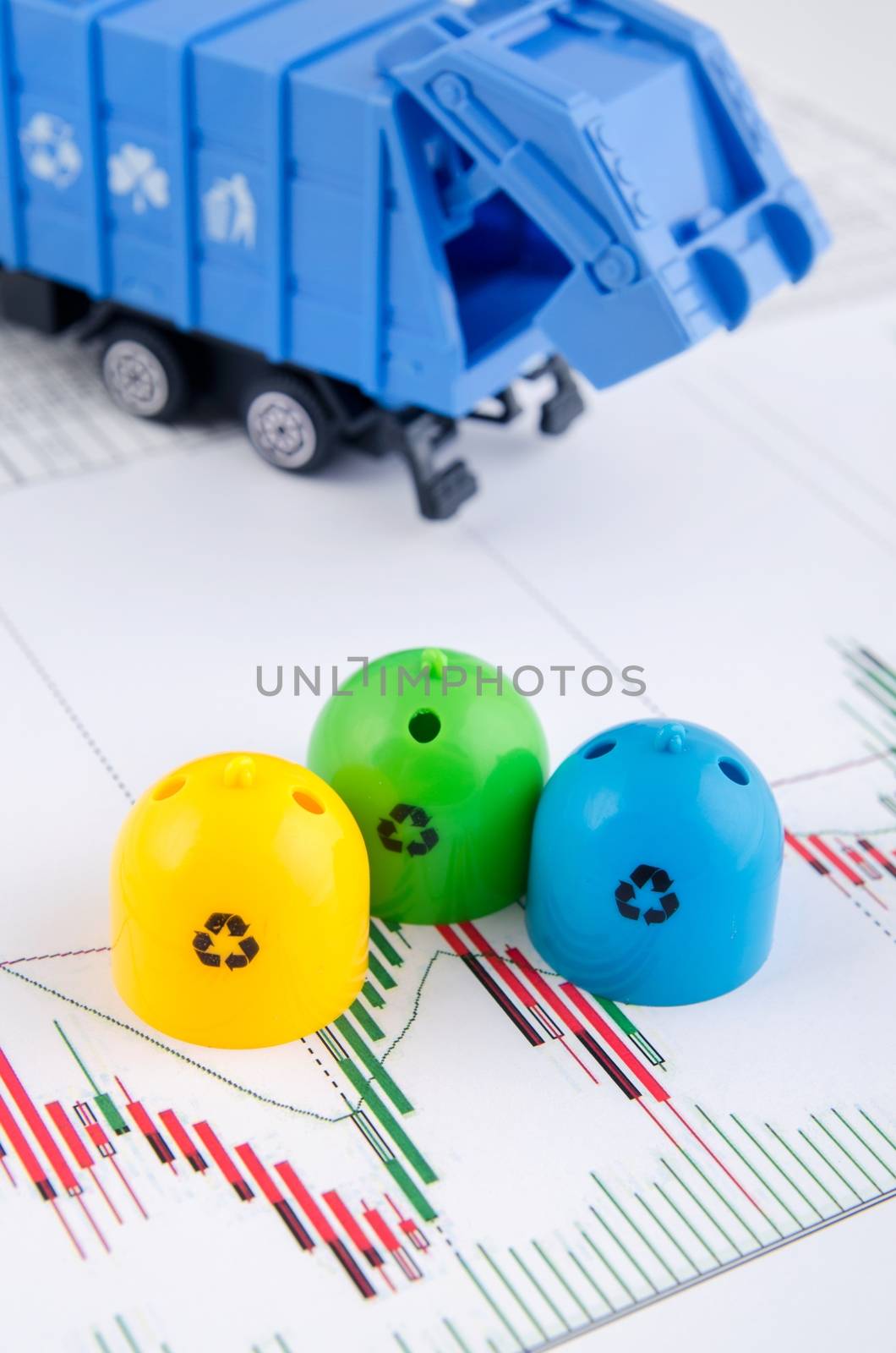 Colored trash bins and garbage truck toys on business background