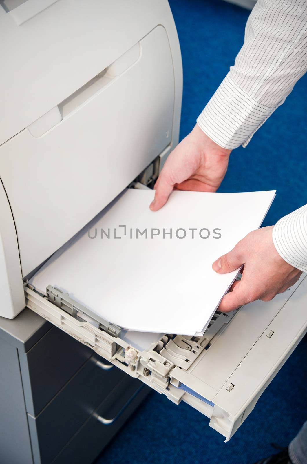 Man puts the paper in a laser printer by simpson33