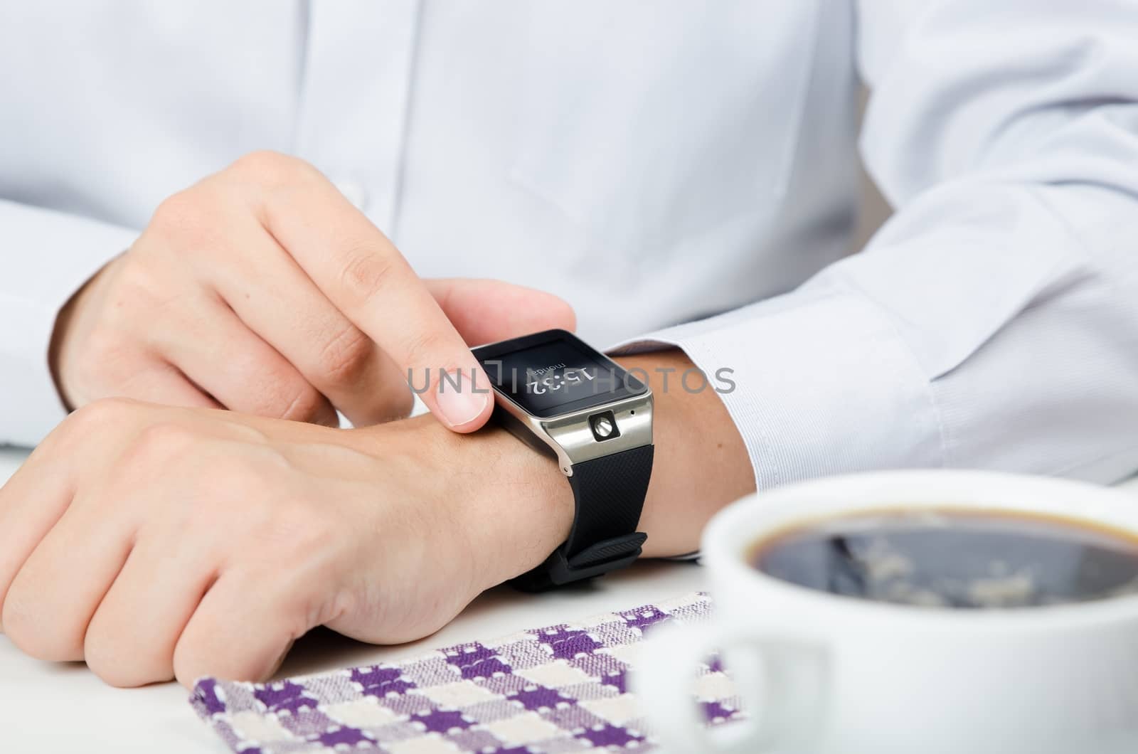 Businessman working with smart watch in restaurant. Coffee on the table 