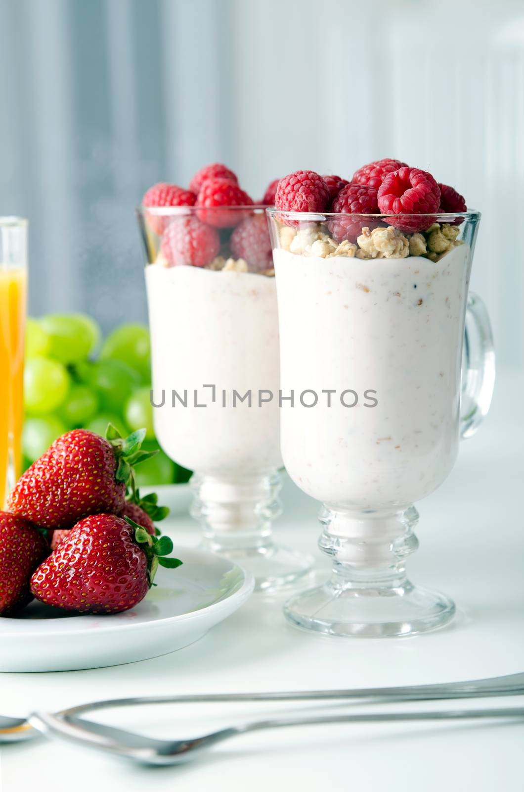 Glass of dessert with fresh berries, muesli and yoghurt on table