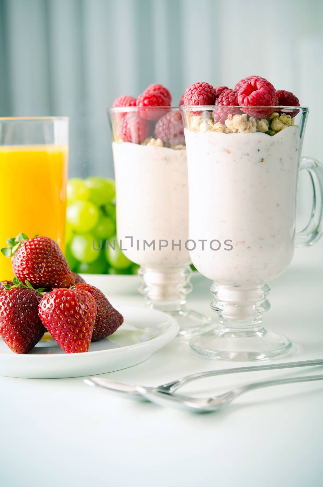 Glass of dessert with fresh berries, muesli and yoghurt on table