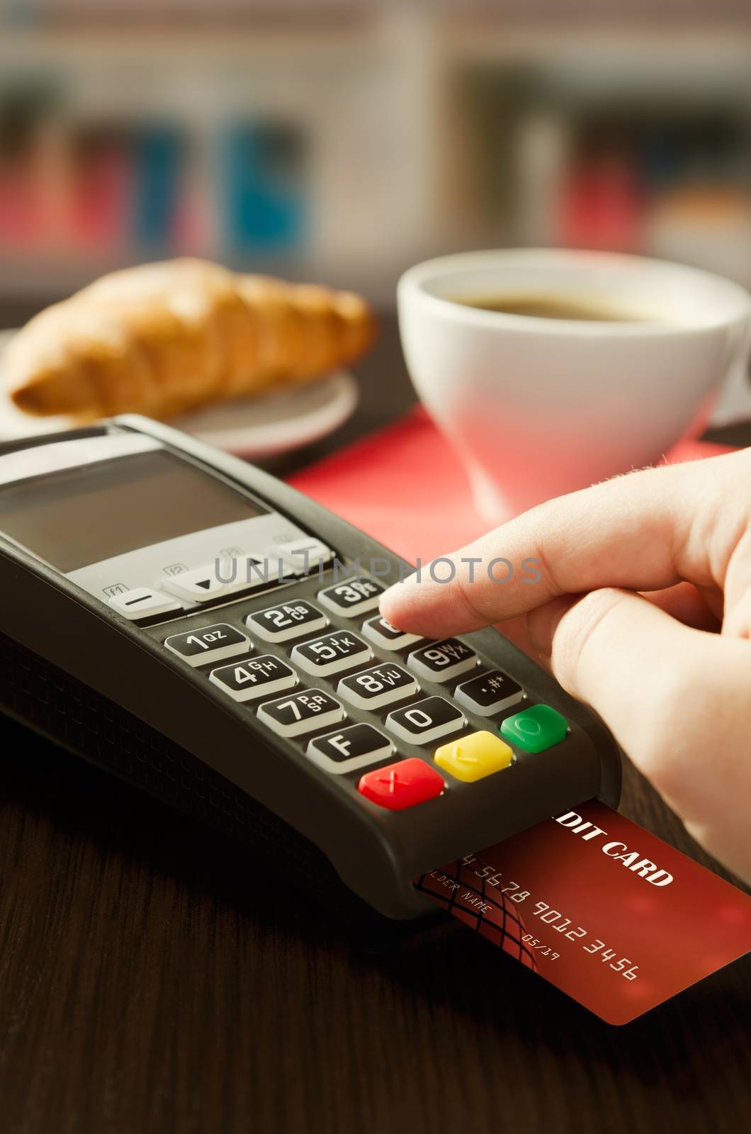 Man making payment with terminal for sale in cafeteria by simpson33