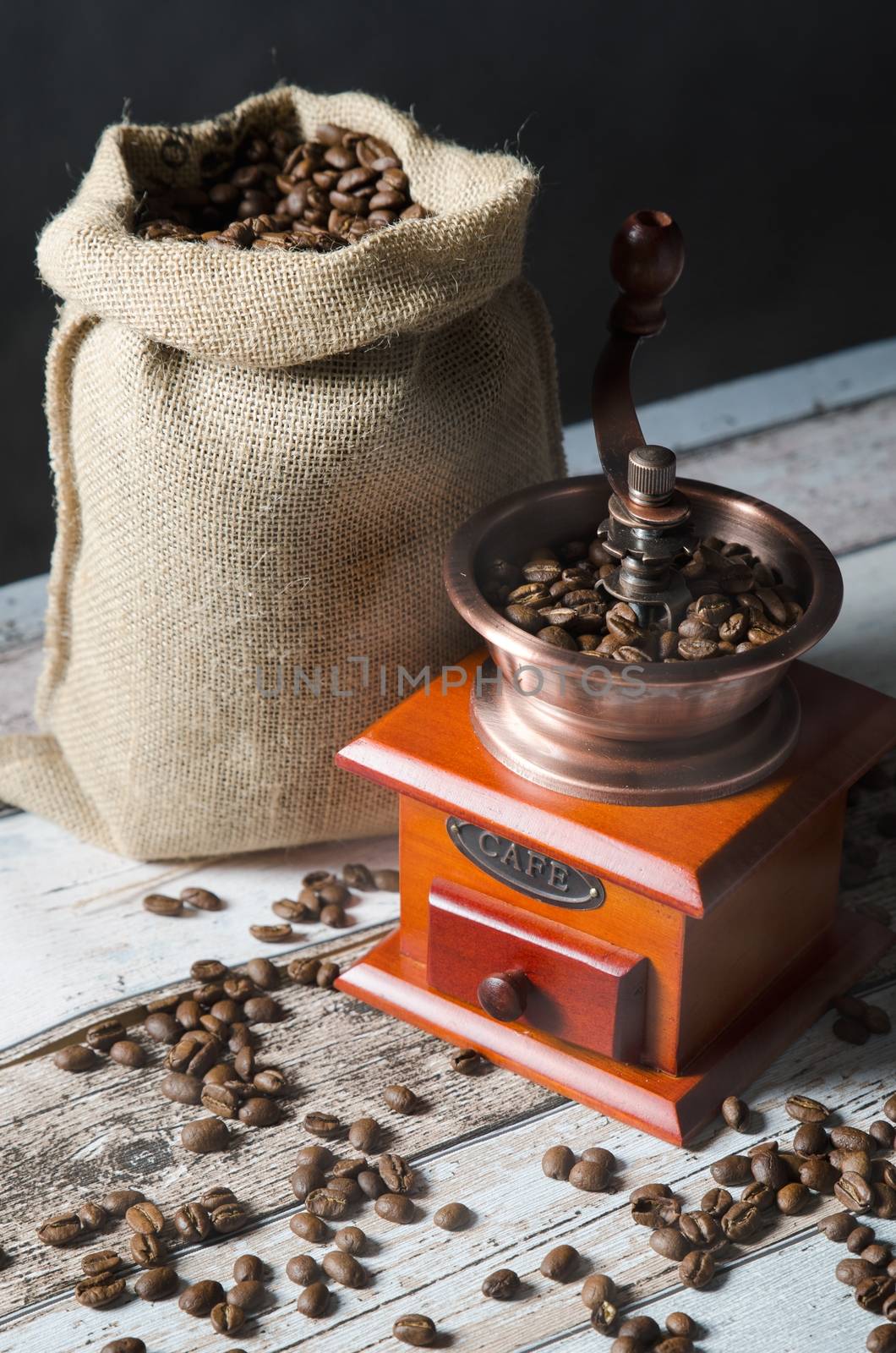 Coffee grinder with roasted beans. Vintage mill composition by simpson33