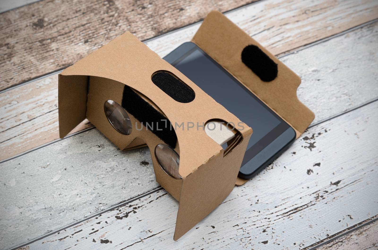 Virtual reality cardboard glasses. Easy way to watch movies in 3D. Shoot on wooden background.