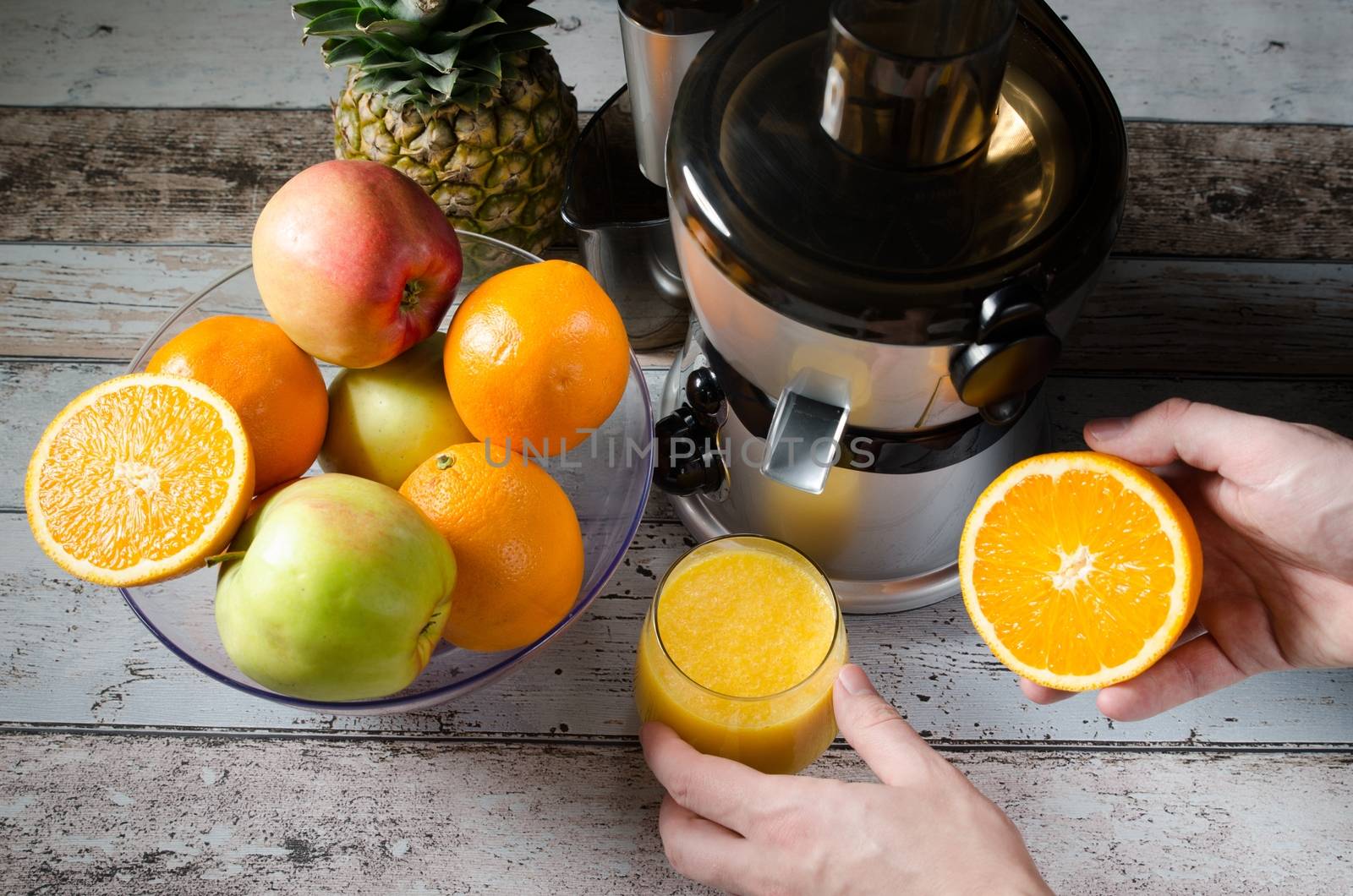 Man preparing fresh orange juice. Fruits in background by simpson33