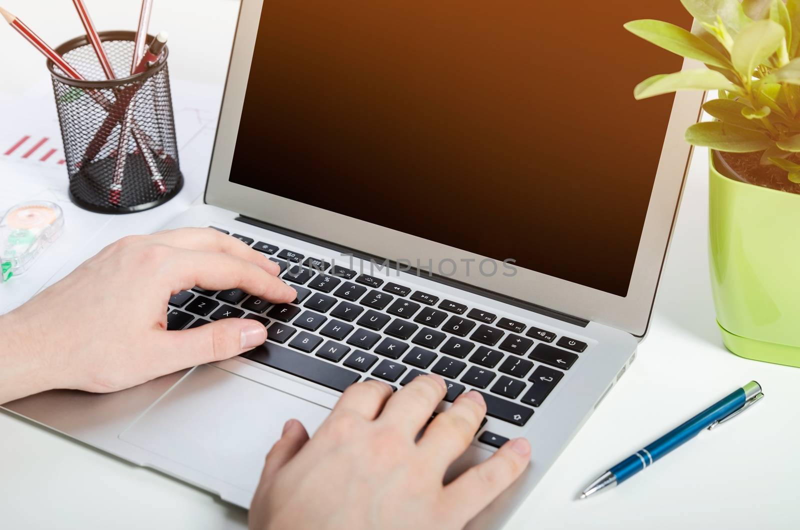 Man working with modern laptop in office. Hands typing on keyboard