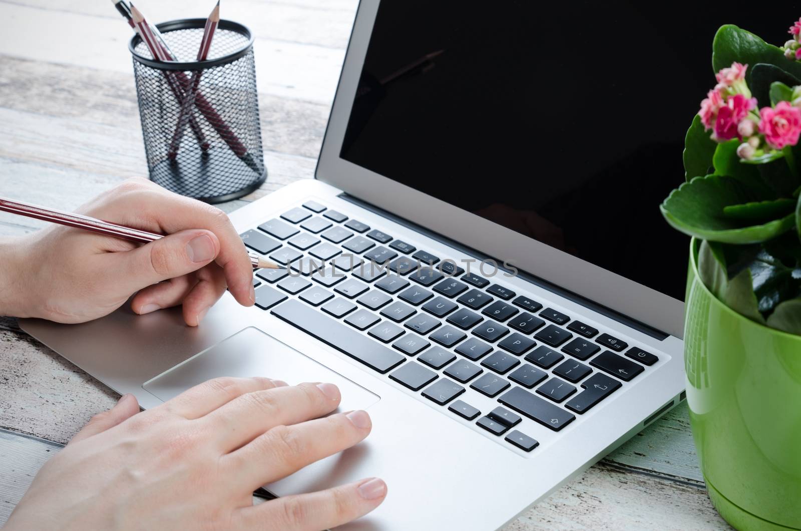 Man working with modern laptop in office. Hands typing on keyboard