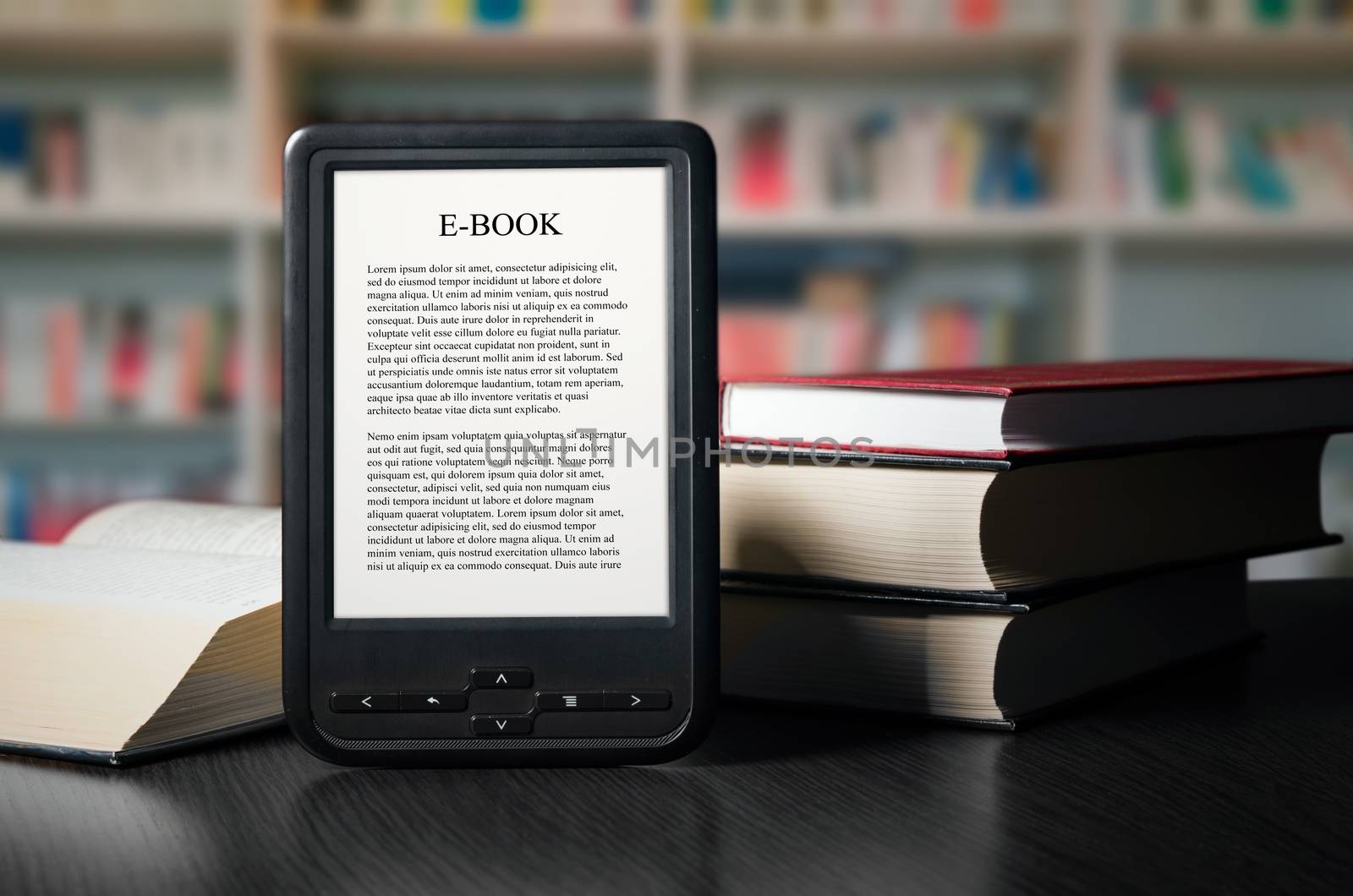 E-book reader device on desk in library by simpson33