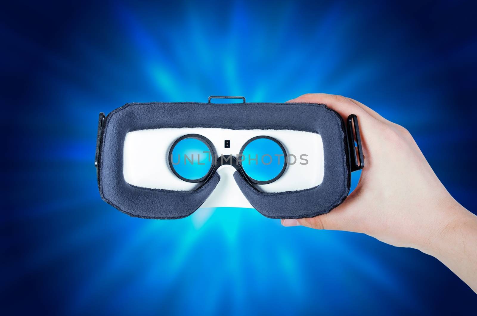 Hand holding virtual reality glasses with streaming multimedia in background