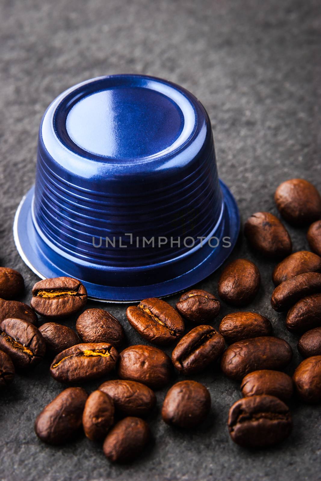 Coffee capsule and coffee beans  on the dark table vertical