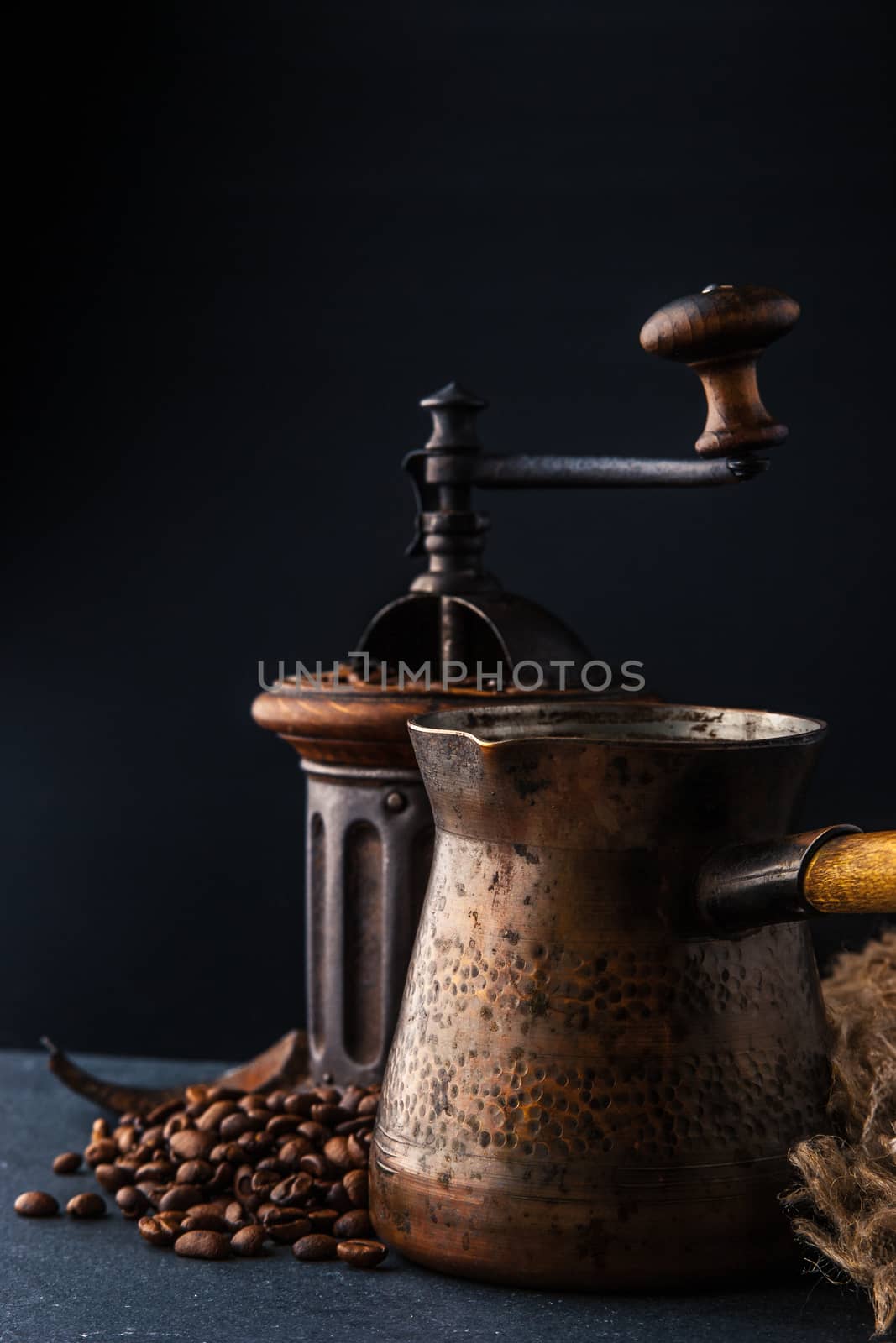 Coffee mill and cezve on the dark table vertical