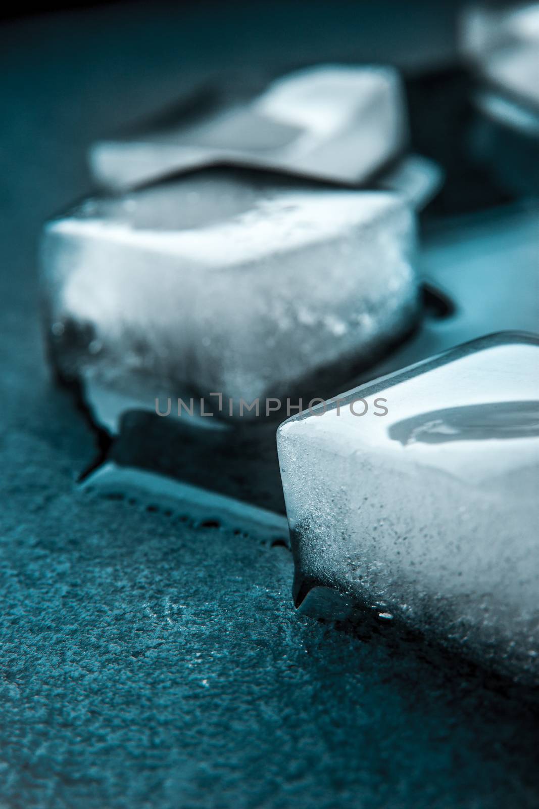 Ice cubes on the dark stone table vertical