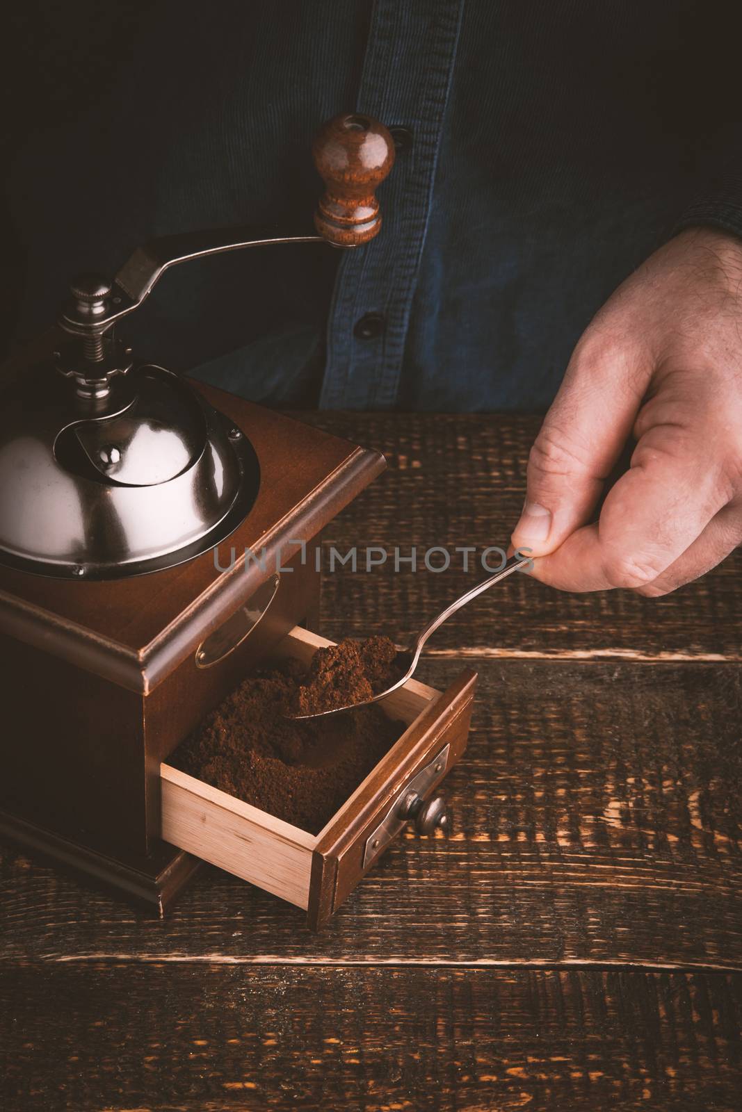 Man making coffee with coffee mill vertical by Deniskarpenkov