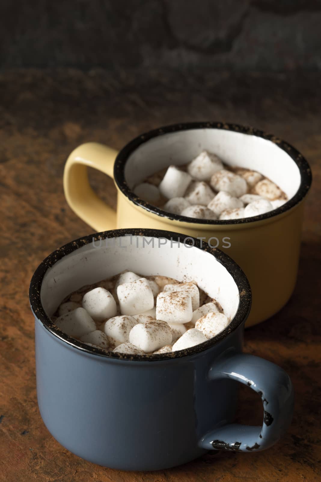 Cups of cocoa with marshmallows on the stone table vertical