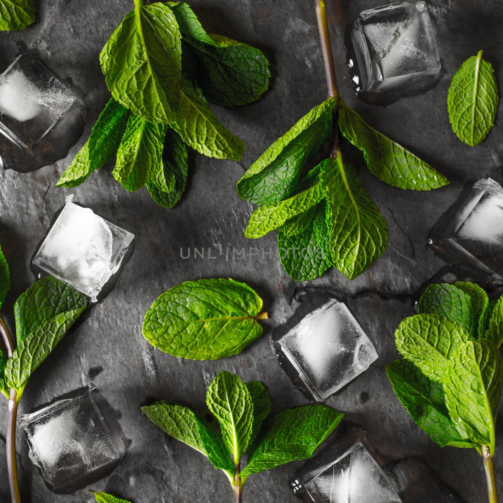 Fresh mint with ice cube on the stone table square by Deniskarpenkov