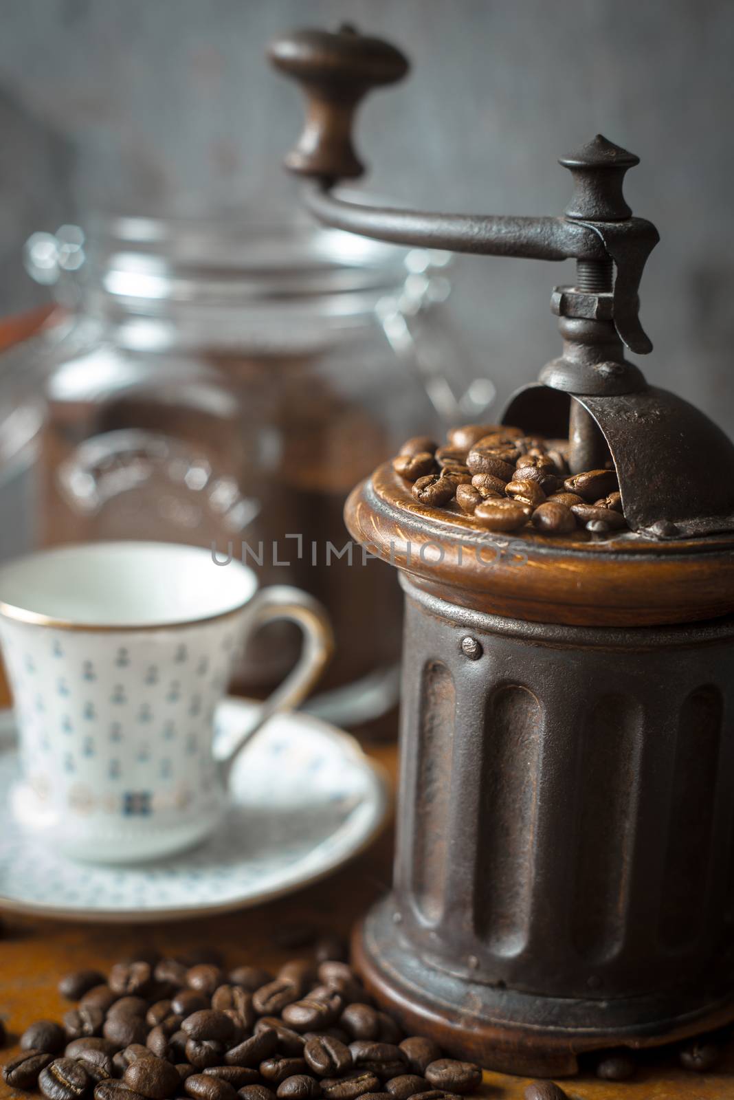 Coffee mill with coffee beans and blurred cup