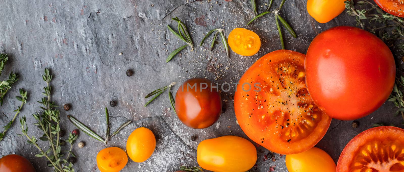 Tomatoes mix  with herbs on the stone table wide screen by Deniskarpenkov