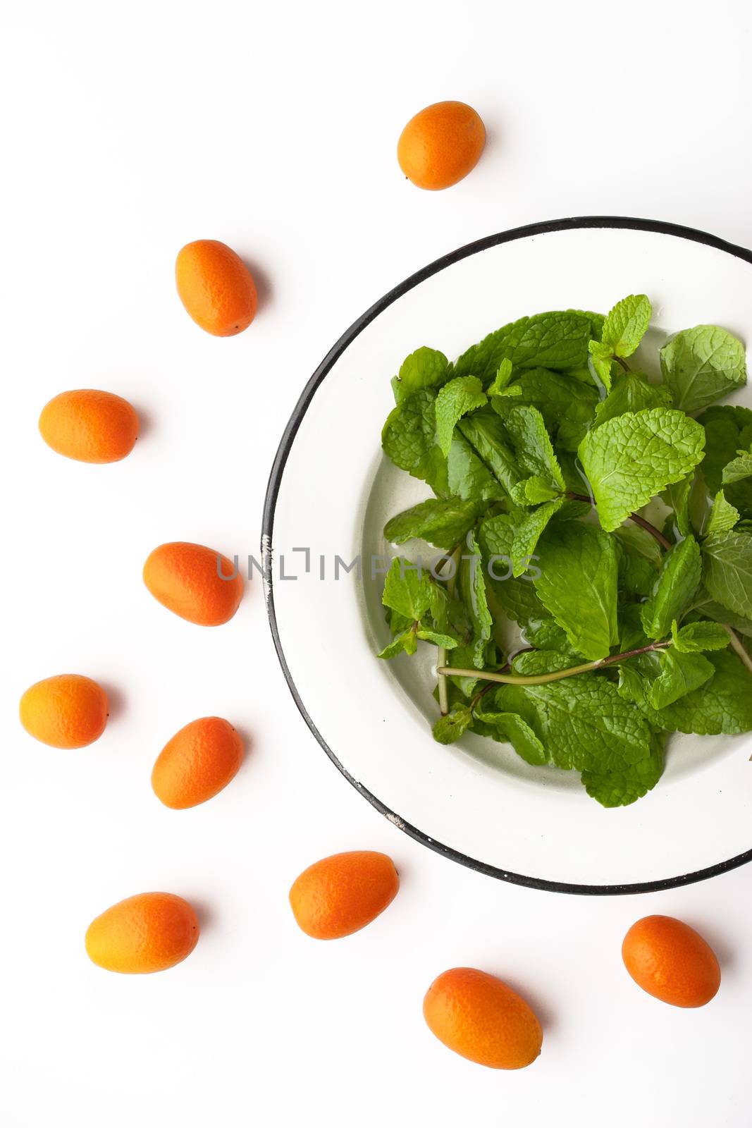 Mint with kumquat on the white background vertical