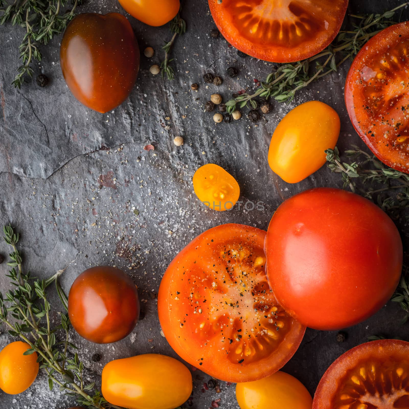 Tomatoes mix  with herbs on the stone table square by Deniskarpenkov