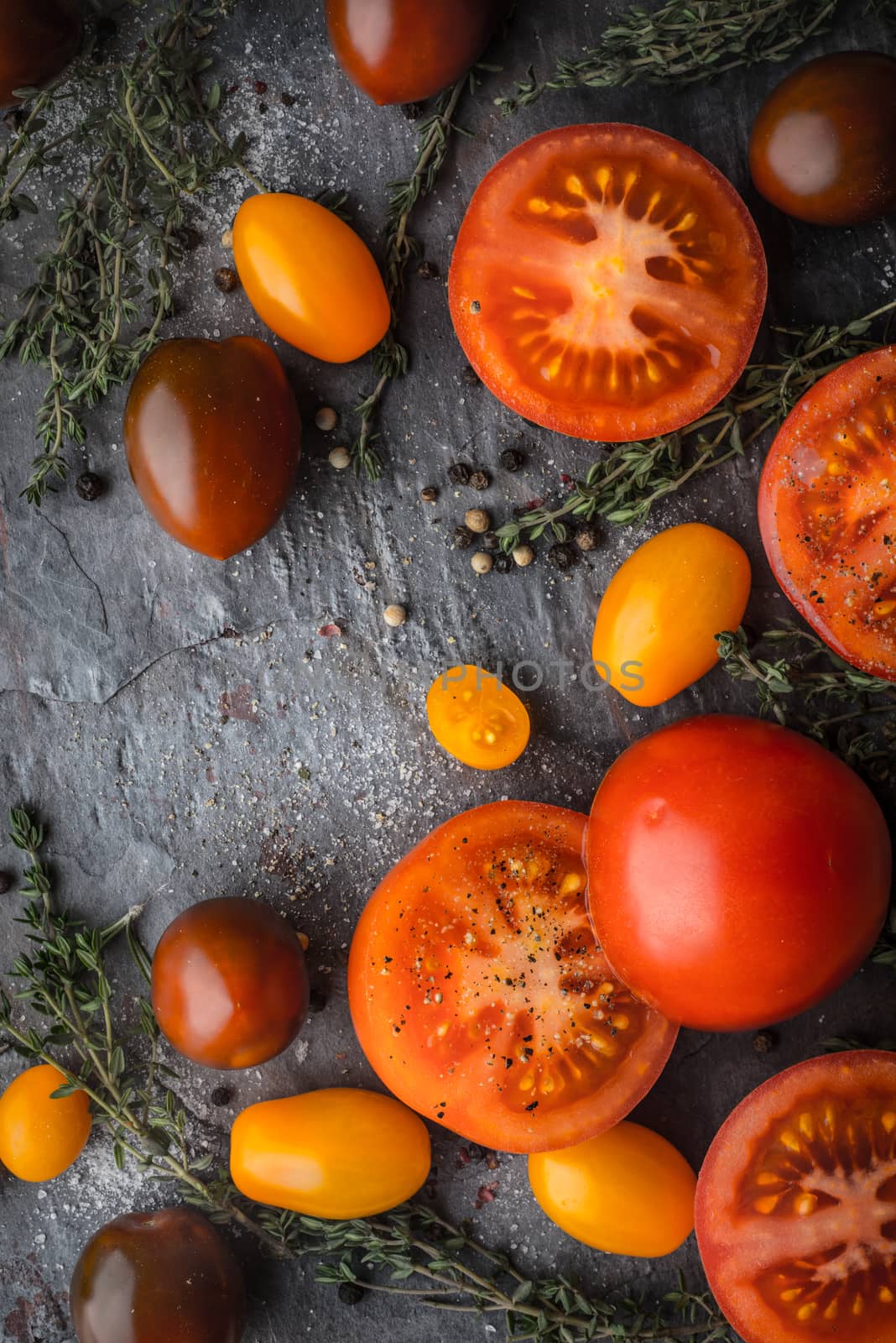 Tomatoes mix  with herbs on the stone table vertical