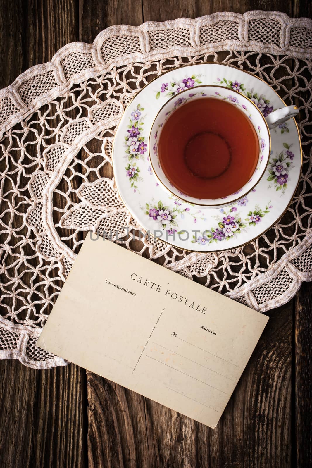 Cup of tea with postcard  on the wooden table