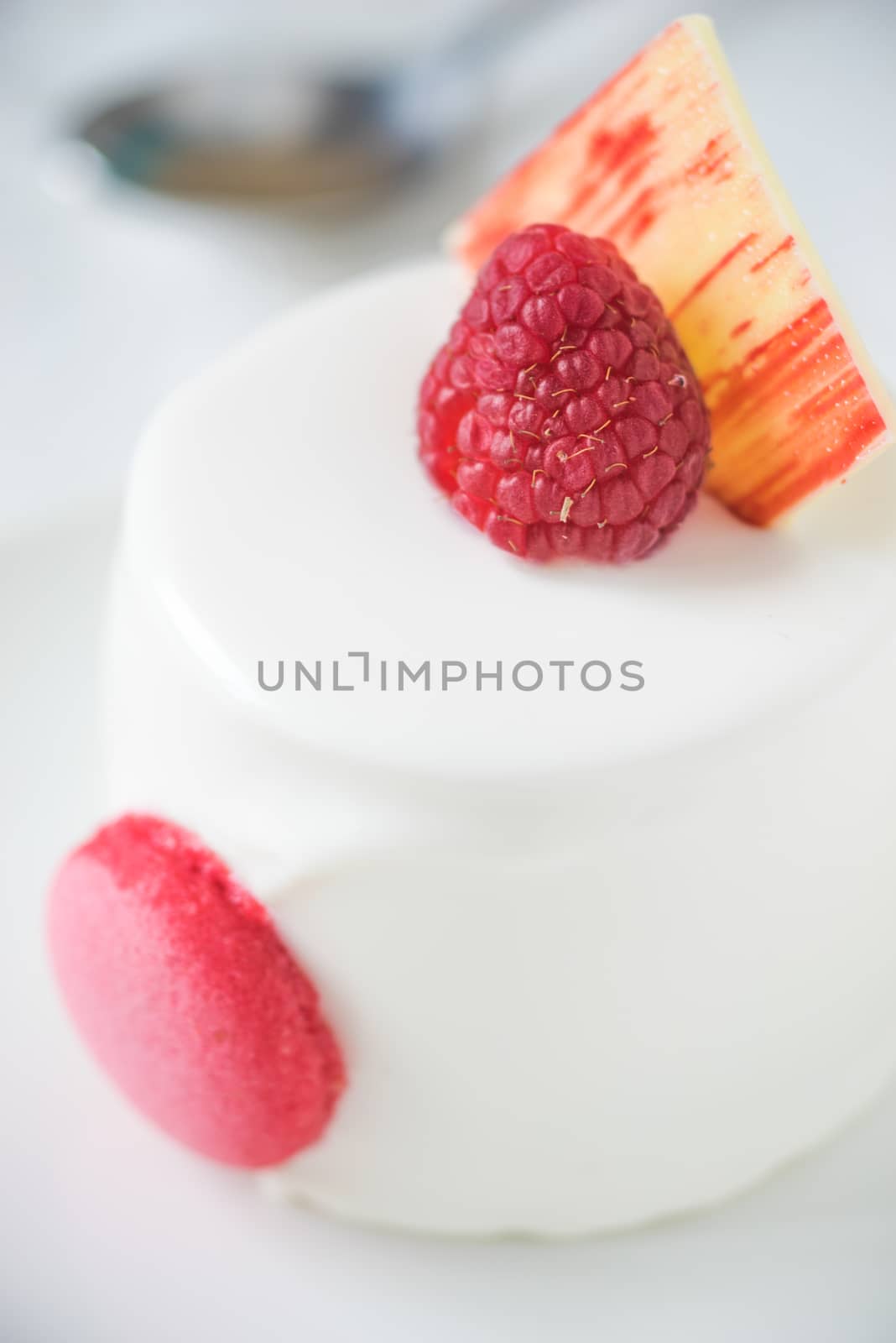 White cake with raspberry vertical