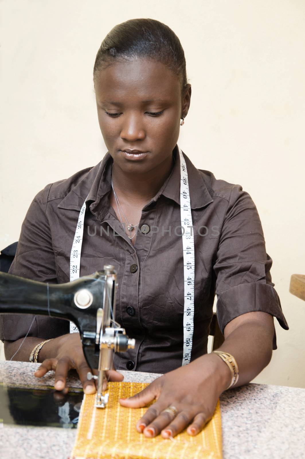 This young woman seamtress sitting , focused on her work is sewing  a loincloth.