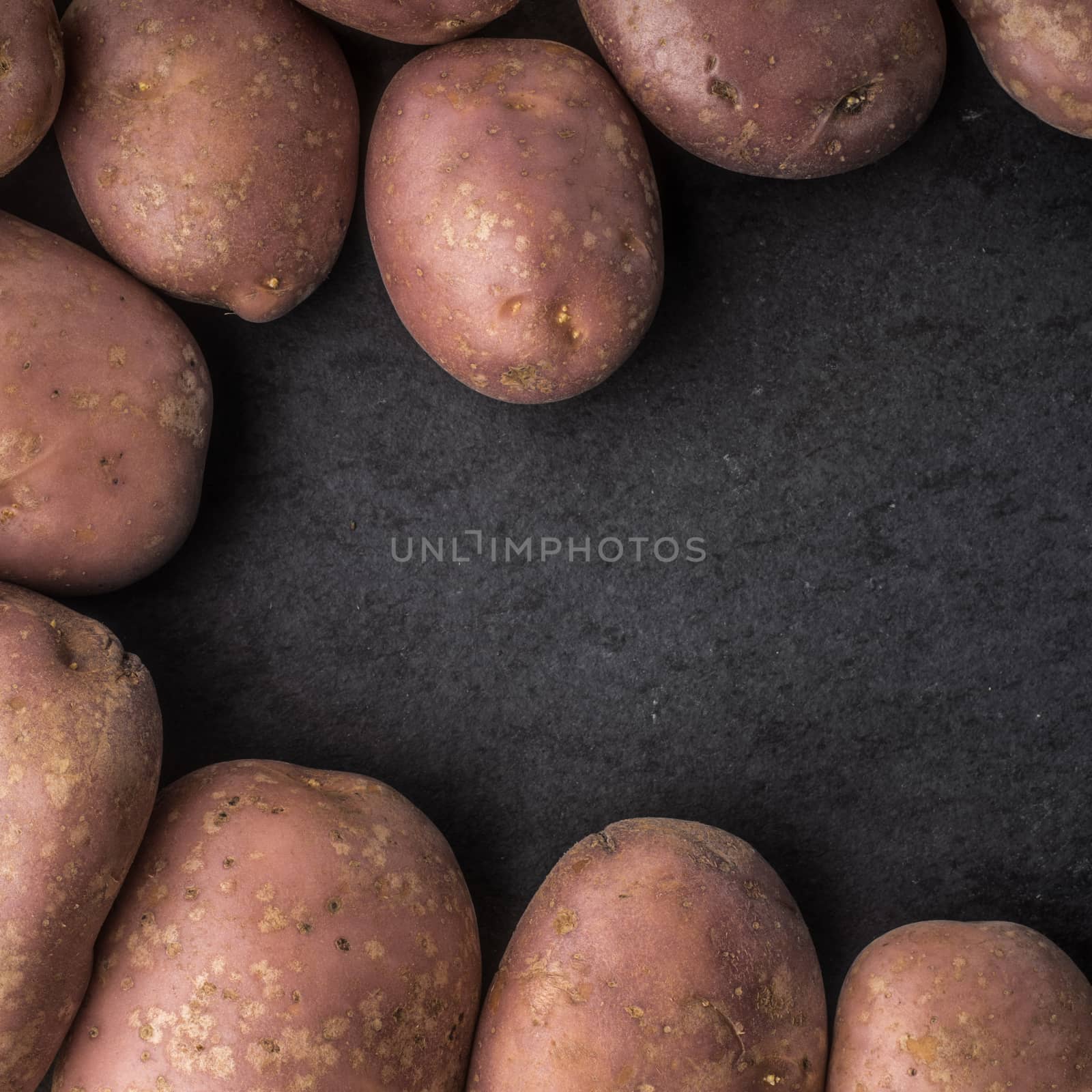 Raw potatoes at the left of the black stone table square