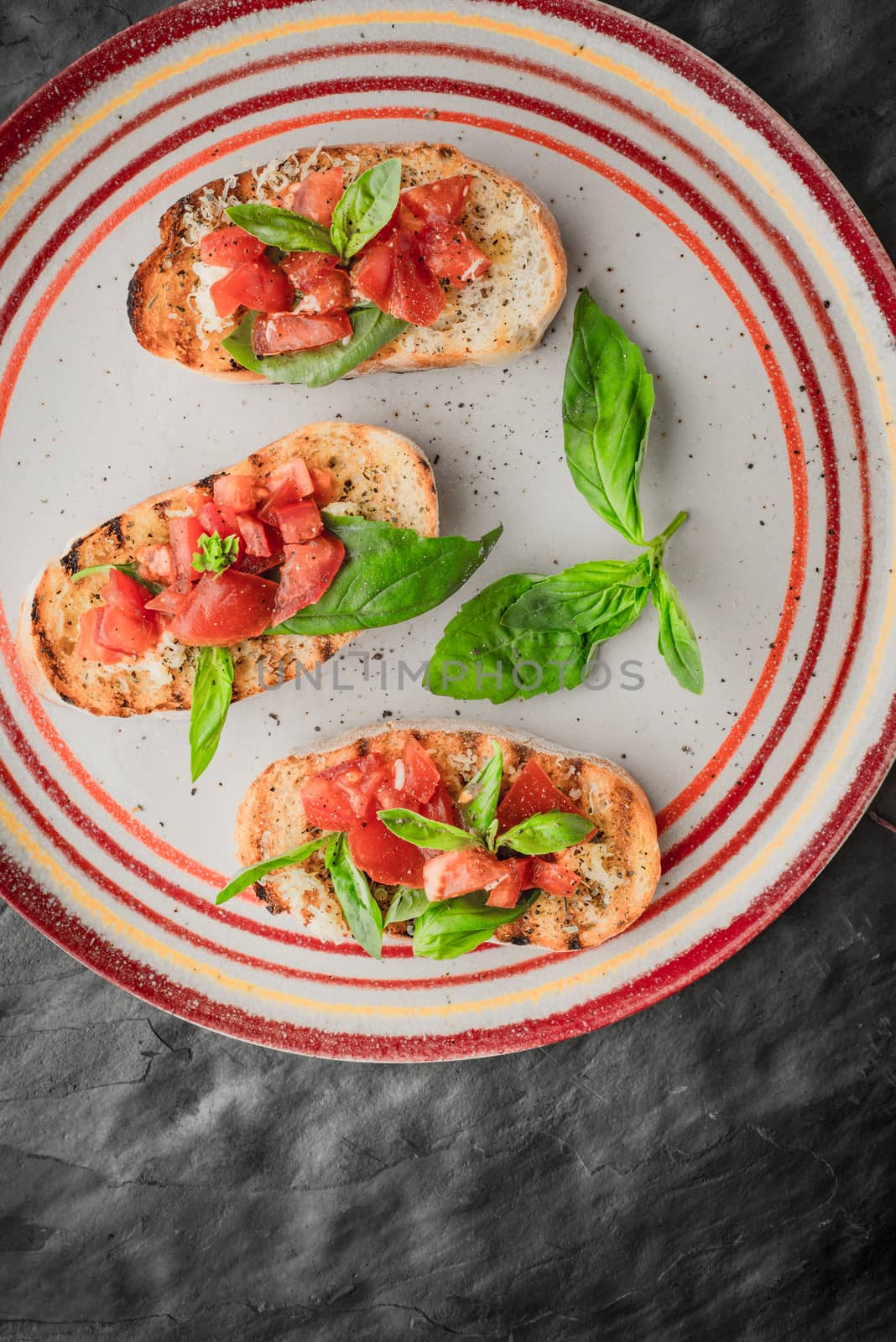 Bruschetta with tomatoes and basil on the stone table top view