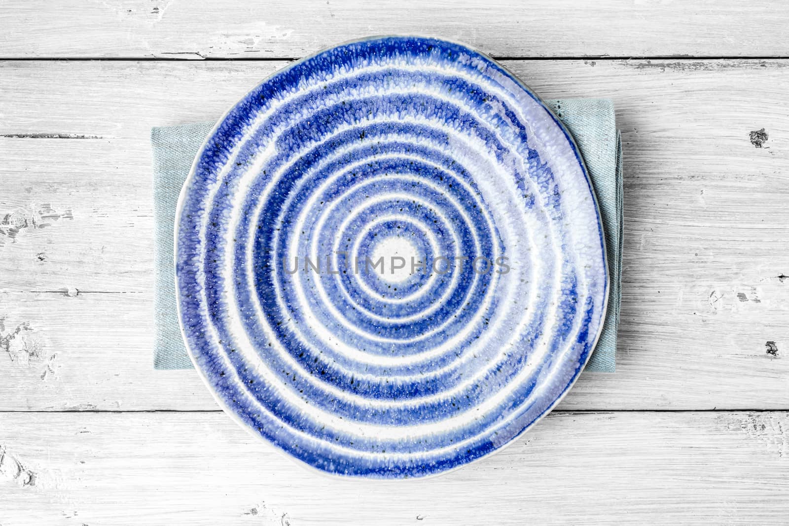 Blue and white ceramic plate on the white wooden table