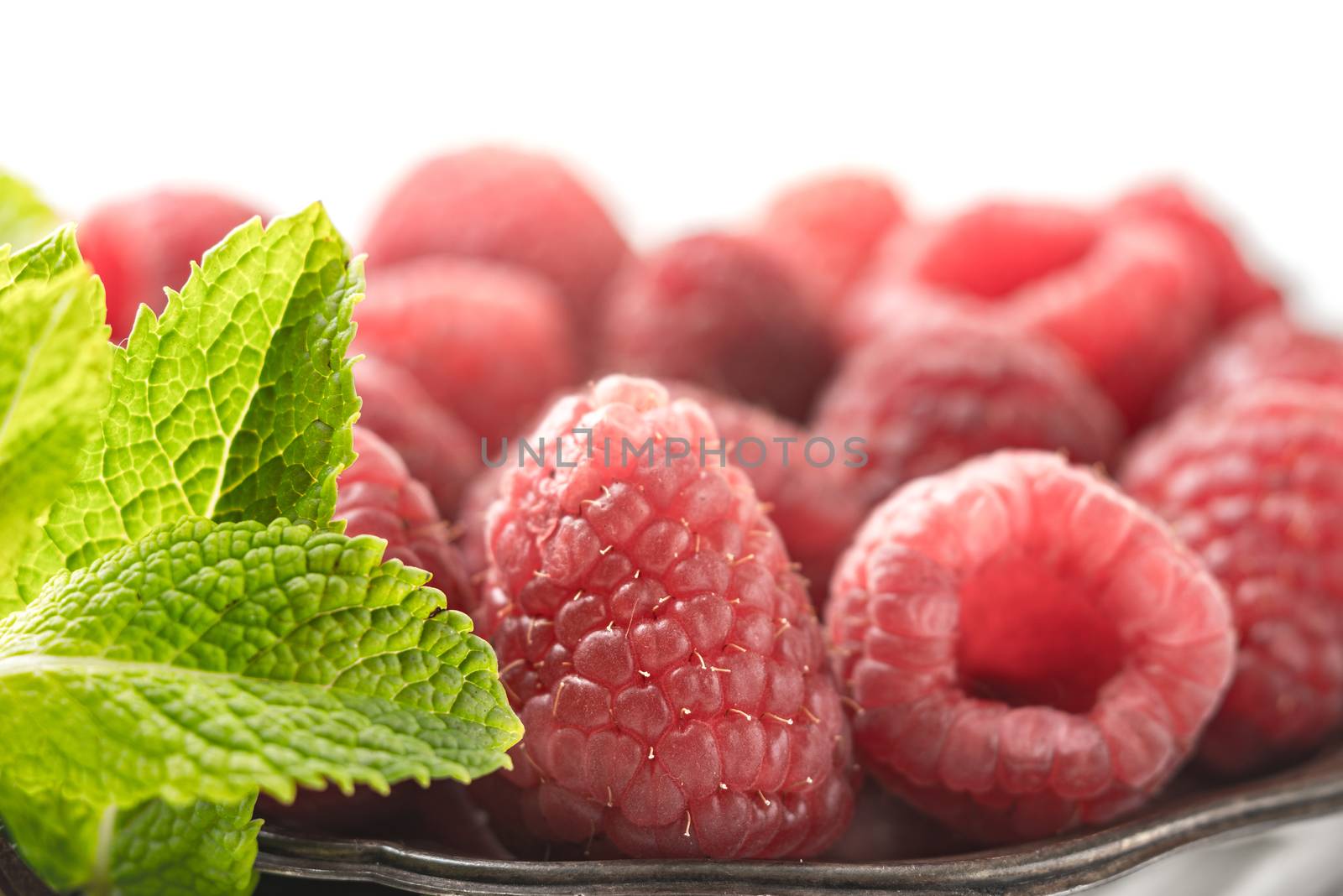 Raspberries with mint on the metal plate