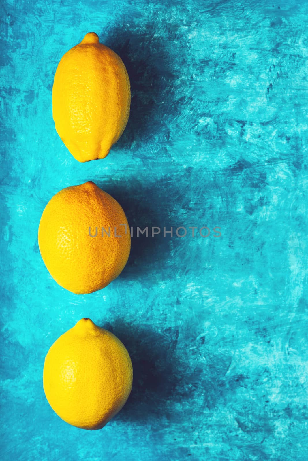 Yellow lemons on the cyan background vertical