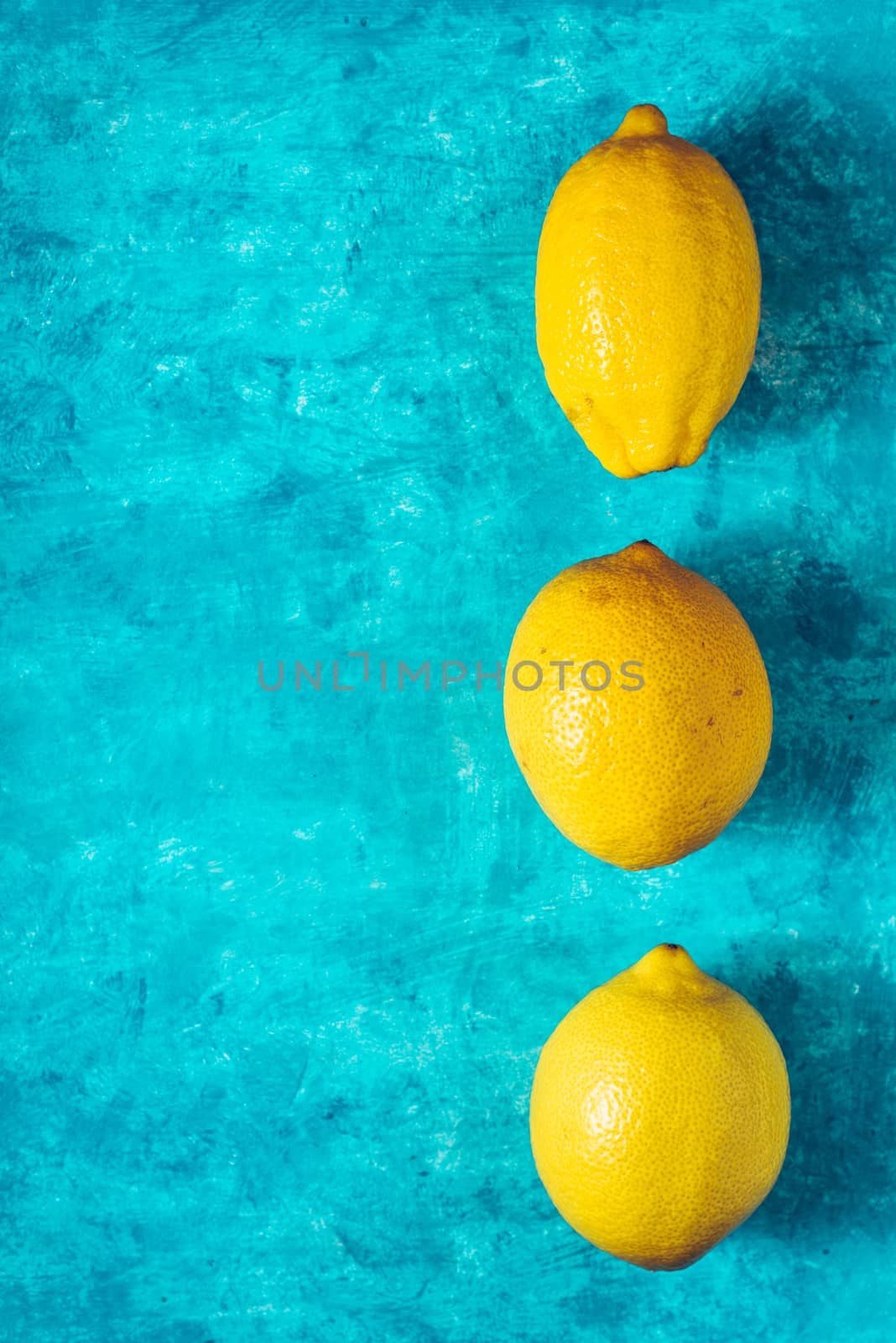 Yellow lemons on the cyan background top view