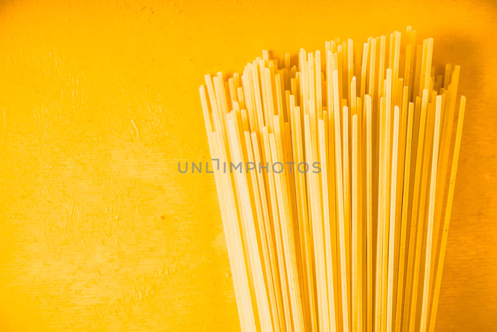 Raw spaghetti on the yellow background horizontal