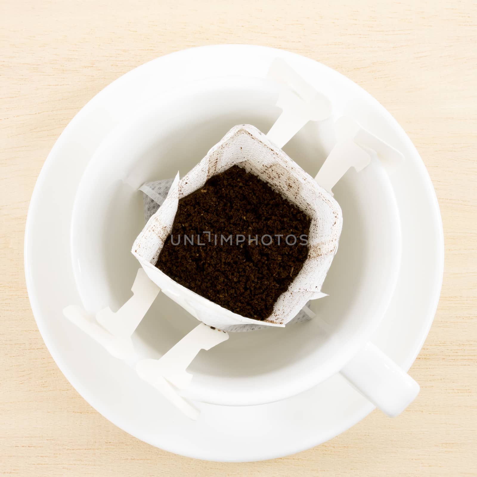 The instant freshly brewed coffee drip bag on white coffee cup.